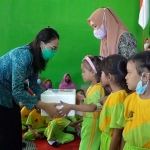 Ketua Tim Penggerak PKK Kabupaten Kediri Eriani Annisa Hanindhito saat membagikan paket makanan olahan ikan kepada anak-anak. Foto: Ist.