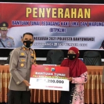 Petugas dari Polresta Banyuwangi saat memberikan bantuan secara simbolis kepada penerima manfaat