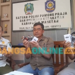 Kabid Gakda Satpol PP dan Damkar Magetan bersama petugas dari Bea cukai saat menunjukkan rokok ilegal. Foto: HENDRO SUHARTONO/BANGSAONLINE