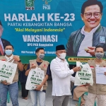 H. Syafiuddin, Ketua DPC PKB Bangkalan saat memberikan sembako kepada masyarakat yang mengikuti vaksinasi. foto: FAUZI/ BANGSAONLINE