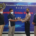 Kasubbag Humas Polres Kediri Kota Kompol Kamsudi saat menyerahkan kue ulang tahun kepada Ketua PWI Kediri Mega Wulandari. (foto: MUJI HARJITA/ BANGSAONLINE)