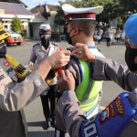 Wakapolres Kediri, Kompol Hendry Ibnu Indarto, saat menyematkan pita kepada salah satu petugas. Foto: Ist