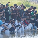 Pj Bupati Nganjuk saat melepaskan bibit ikan di Bendungan Semantok. 