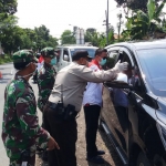 Petugas gabungan menepikan satu per satu kendaraan yang melintas di 5 titik perbatasan Kabupaten Jember untuk dilakukan screening.