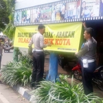 Petugas Satlantas Polres Tuban sedang memasang banner imbaun tertib berkendara dan larangan untuk tidak melakukan arak-arakan. Foto: GUNAWAN WIHANDONO/BANGSAONLINE