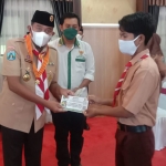 Bupati Sumenep Achmad Fauzi saat menyerahkan santunan kepada anak yatim dan anak dhuafa pada acara Upacara Peringatan Hari Gerakan Pramuka Nasional.