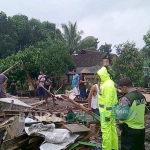 Petugas mendata sejumlah rumah yang rusak parah akibat tertimpa pohon. foto: AKINA/ BANGSAONLINE