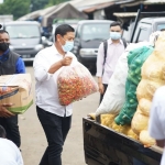 Wali Kota Kediri Abdullah Abu Bakar saat ikut membantu mengangkat lombok untuk dinaikkan ke mobil yang akan dibawa ke Lumajang. foto: ist.