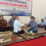 Wabup Noor Nahar Hussein menerima potongan tumpeng dari Ketua PWI Tuban Pipit Wibawanto.