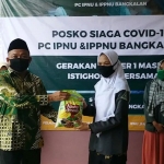 H. Syafiuddin Asmoro memberikan sumbangan beras dan masker secara simbolis kepada Fatimatuz Zuhroh, Ketua IPPNU Bangkalan.