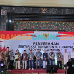 Wakil Menteri ATR/Wakil Kepala BPN Raja Juli Antoni menyerahkan sertifikat tanah program PTSL secara simbolis kepada warga Bangkalan (foto:Muzammil/Bangsaonline)