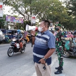 Suhartono saat menyampaikan imbauan kepada pengunjung pasar. (foto: ist)