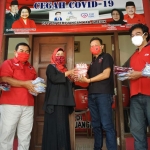 Bendahara PDIP Gresik, Ir. Hj. Siti Muafiyah saat menyerahkan bantuan masker di posko gotong royong cegah COVID-19. foto: SYUHUD/ BANGSAONLINE