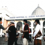 Cek suhu tubuh calon jamaah salat Idul Adha di masjid Al Akbar diperiksa oleh petugas. Ini merupakan penerapan protokol kesehatan pencegahan Covid-19. foto: istimewa.