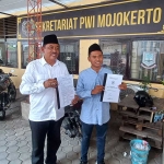 Kades Juriyanto didampingi anaknya saat melakukan jumpa pers di Kantor PWI Mojokerto.