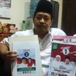 Gogot Cahyo Baskoro, Komisioner KPU Jatim menunjukkan contoh materi APK dan BK resmi dari KPU. Foto: Didi Rosadi/BANGSAONLINE 