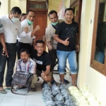 Tersangka AS (jongkok pegang tas) saat diamankan beserta barang bukti puluhan kilogram bahan peledak.