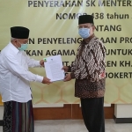 Prof Dr Suyitno, MAg, Dirjen Pendidikan Tinggi Keagamaan Islam Direktorat Jenderal Pendidikan Kementerian Agama menyerahkan SK ijin penyelenggaraan program studi pendidikan agama Islam untuk program doktor pada IKHAC yang diterima Prof Dr KH Asep Saifuddin Chalim, MA , di PP Amanatul Ummah Surabaya,Selasa (4/5/2021). Foto: mma/bangsaonline.com