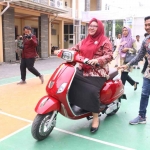 Wabup Aminatun Habibah saat menjajal motor listrik. FOTO: SYUHUD/BANGSAONLINE.com