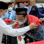 Direktur SDM dan Umum SIG, Agung Wiharto (kiri) menyematkan syal kepada Eko Cahyono, Calon jemaah Haji saat pemberangkatan di Wisma A. Yani, Gresik, Rabu (15/6/2022). Foto: ist.