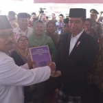 KH. Muchlis Muchsin menyerahkan surat mandat 1000 tanda tangan kiai dan pengasuh pondok pesantren, pengasuh madrasah dan guru ngaji se-Madura kepada Presiden Jokowi.
