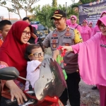 Ketua Bhayangkari Cabang Bangkalan Ny. Andrea Boby beserta Kapolres Bangkalan AKBP Boby P. Tambunan memberikan takjil di depan Mapolsek Kamal Bangkalan, Rabu (14/5).