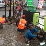 Petugas saat membersihkan sampah yang menyumbat aliran. Foto: Ist.