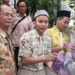 Khoirul Anam, Kasek SMPN 1 mendampingi siswa bagi-bagi sembako.