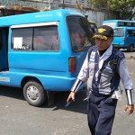 Seorang petugas UPT PPP LLAJ Dishub Jatim harus bersusah payah menghalau sopir bus atau angkot agar masuk ke terminal. 