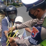 Dalam sosialisasi kali ini, petugas memasangkan janur kuning pada pengendara untuk memberikan tanda bagi pengendara lain agar lebih bisa waspada.