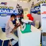 Pengunjung MotoGP Mandalika melakukan transaksi pengiriman di stan JNE. foto: ist.