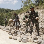 Anggota TNI bersama warga kebut pembangunan pembukaan jalan baru di Desa Lengkong Lor, Kecamatan Ngluyu, sebagai penghubung menuju Desa Losari, Kecamatan Gondang, Nganjuk. foto: BAMBANG/ BANGSAONLINE