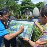 Bupati Sambari didampingi Ketua DPRD Gresik Abdul Hamid membubuhkan tanda tangan di salah satu foto yang dipamerkan. foto: SYUHUD/ BANGSAONLINE