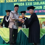 Bupati Tuban, H Fathul Huda saat memberikan piagam kepada salah satu wisudawan berprestasi.