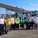 Prof Dr KH Asep Saifuddin Chalim, MA bersama rombongan foto bersama dengan latar belakang pesawat Susi Air di lapangan terbang Harun Thohir Bawean, Gresik, Jawa Timur, Jumat (26/5/2023). Foto: BANGSAONLINE