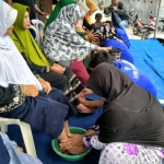 Anak-anak sedang membasuh kaki ibu saat HUT LSM FPSR. foto: SYUHUD/ BANGSAONLINE