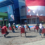 Bendara merah putih raksasa dipasang di atas Gedung Olahraga (GOR) Mastrip oleh sejumlah atlet panjat tebing.