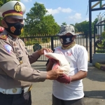 Jajaran Satlantas Polres Pamekasan saat membagikan sembako dan masker bagi para pengendara kendaraan bermotor di wilayah hukumnya. 