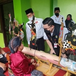 Bupati Kediri, Hanindhito Himawan Pramono, saat meninjau pelaksanaan vaksinasi di MIN 2 dan disambut oleh siswa kelas 2, Moh Iqbal Maulana (9),  yang memainkan wayang punokawan di depan kelas. Foto: Ist