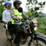 Mensos RI Khofifah Indar Parawansa naik tril digonceng Kapolsek Sidamulih Pangandaran menuju lokasi korban bencana. Foto: istimewa