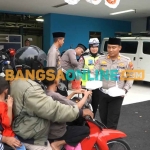 Kasatlantas Polres Gresik, AKP Agung Fitransyah, saat memberikan takjil kepada masyarakat. Foto: SYUHUD/BANGSAONLINE