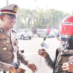 Kasatlantas Polres Pasuruan AKP Evon Fitriyanto sosialisasi Tilang Online dengan cara membagi bunga kepada pengendara.