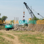 Aktivitas pengerjaan tiang pancang rekonstruksi Jembatan Kacangan, Kecamatan Benjeng, Gresik. Foto: SYUHUD/BANGSAONLINE
