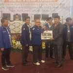 Ketua KPU Jatim Choirul Anam menyerahkan surat penetapan kepada Dr. Kuswanto sebagai caleg DPRD Jatim terpilih dari Partai Demokrat Dapil 10, Mojokerto-Jombang. foto: DIDI ROSADI/ BANGSAONLINE