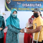 Ketua TP PKK Kabupaten Mojokerto Shofiya Hanak secara simbolis memberikan bantuan berupa beras dan roti kepada para disabilitas yang telah divaksin.