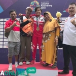 Wiji Lestari foto bersama keluarga didampingi Ketua KONI Blitar di podium.