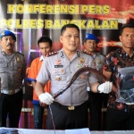 Kapolres Bangkalan AKBP Rama Samtama Putra didampingi Kasatreskrim AKP David Manurung, memperlihatkan barang bukti berupa sebilah celurit untuk menghabisi korban.