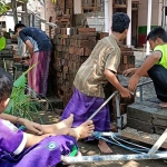 Para santri laki-laki saat ikut membantu mengangkat material di lokasi pembangunan Ponpes Mifa yang baru.
