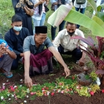 Hariyanto, ayah korban sedang berdoa di pusara putri bungsunya di makam Desa Kabat.