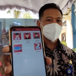 Kades Badalpandean Muhammad Zaenudin saat menunjukkan aplikasi smart connect. (foto: MUJI HARJITA/BANGSAONLINE)